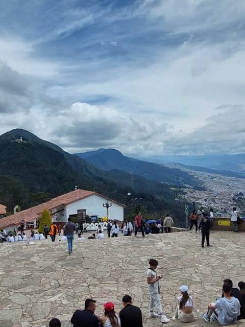 Vista panorámica de un paisaje montañoso con gente reunida en un sendero.