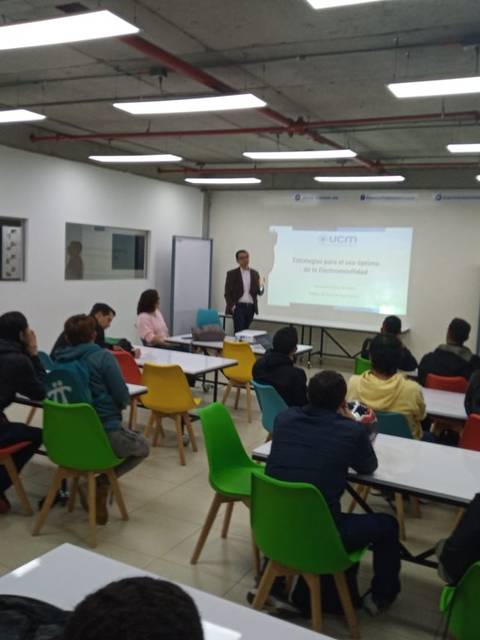 Una presentación en un aula donde varias personas están sentadas mirando a un expositor.
