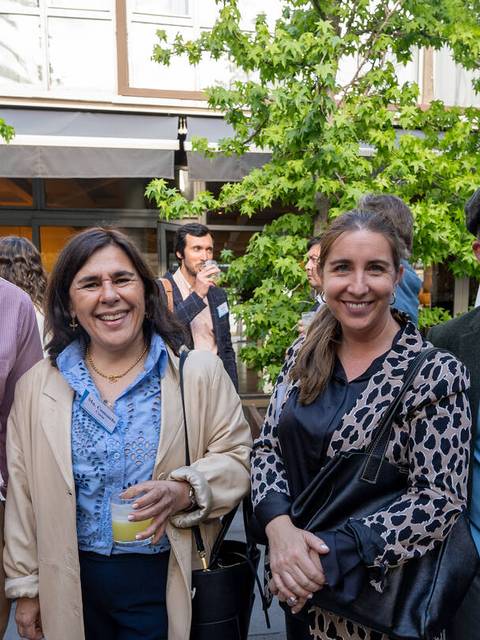 Un grupo de cuatro personas sonríe en un evento al aire libre rodeados de vegetación.