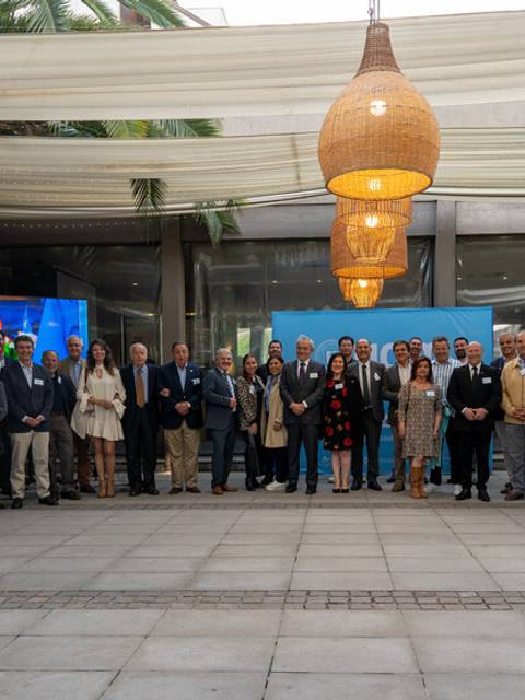 Un grupo de personas posa en un espacio al aire libre con una estructura moderna y bien iluminada.
