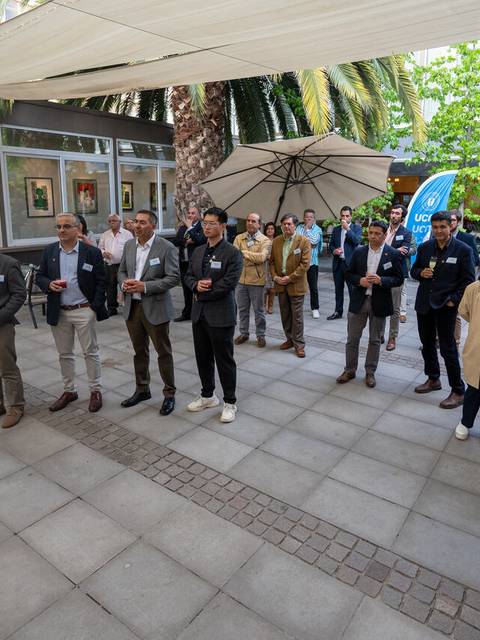 Un grupo de personas asiste a un evento al aire libre en un ambiente soleado y natural.