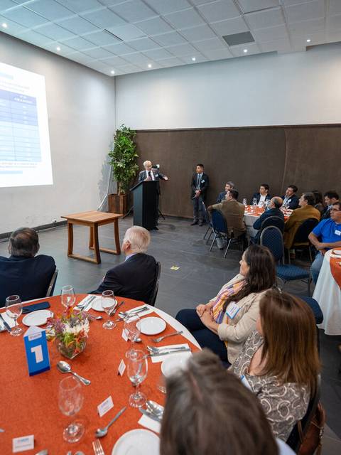 Una reunión en un comedor con un presentador frente a una audiencia.