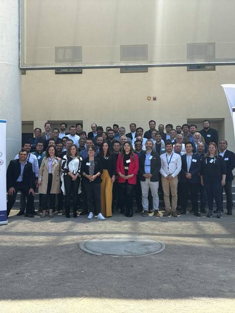 Un grupo de personas posando en un evento al aire libre junto a banners de la UCM y CIIA UCM.
