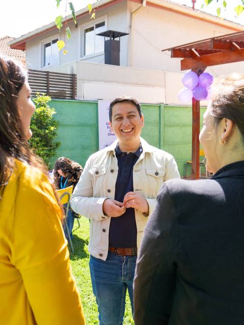 Un grupo de personas conversando en un evento al aire libre con un ambiente festivo.