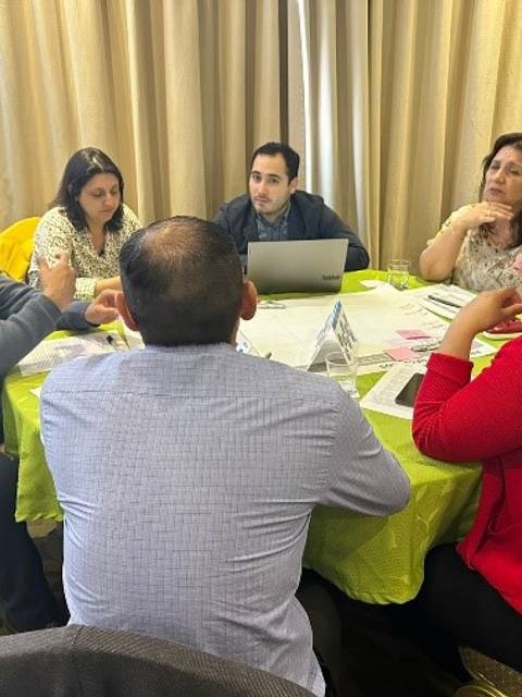 Un grupo de personas discutiendo en una mesa durante una reunión.