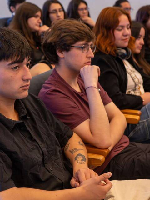 Un grupo de jóvenes escuchando atentamente en un evento.
