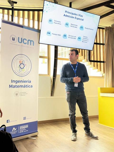 Un hombre presenta información sobre vías de admisión especial en un aula.