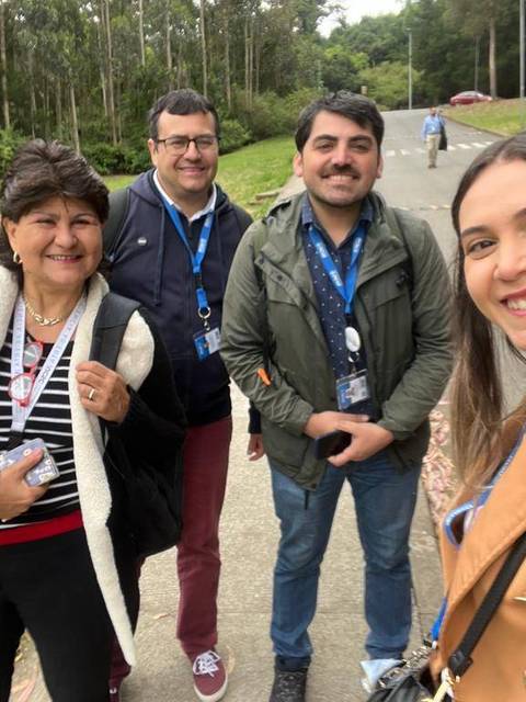 Un grupo de cuatro personas sonríen mientras posan para una foto en un entorno natural.