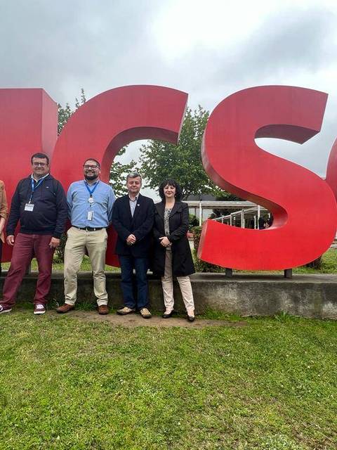 Un grupo de seis personas posa frente a un gran letrero que dice UCSC en un entorno al aire libre.