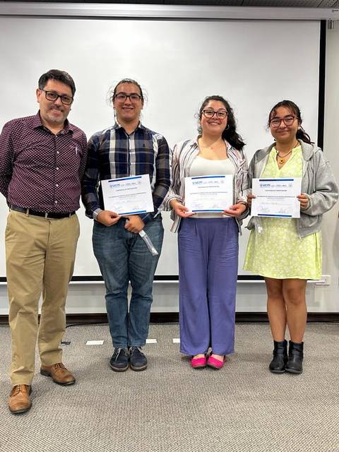 Cuatro personas posan en un evento de entrega de certificados con la bandera chilena de fondo.