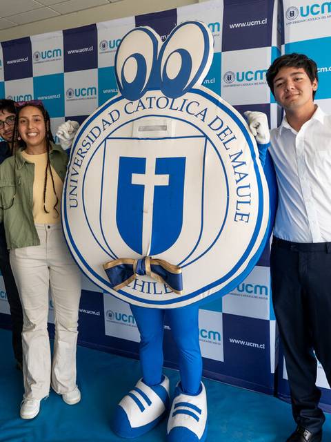 Un grupo de personas posa junto a una mascota de la Universidad Católica del Maule en un evento.