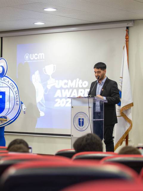 Un hombre habla en un evento de premiación en la Universidad Católica del Maule.