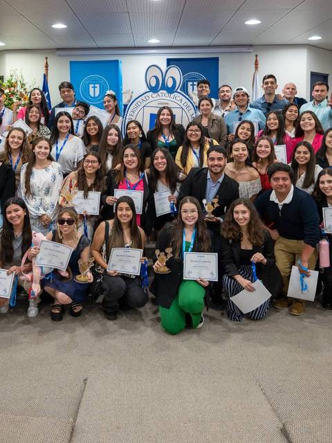 Un grupo de graduados sonríe con sus certificados en un evento organizado por la universidad.