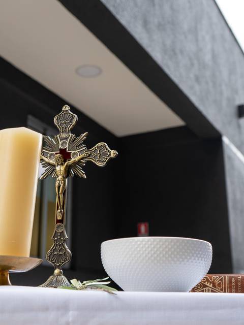 Una ceremonia religiosa se realiza al aire libre con un altar y participantes observando.