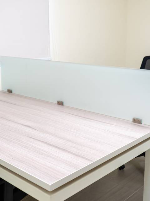 Una oficina moderna con una mesa de trabajo y dos sillas.