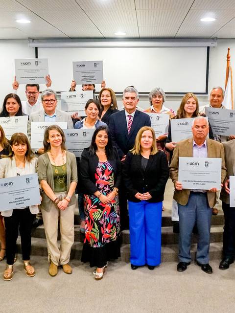 Un grupo de personas posando en un evento, sosteniendo diplomas en un entorno académico.