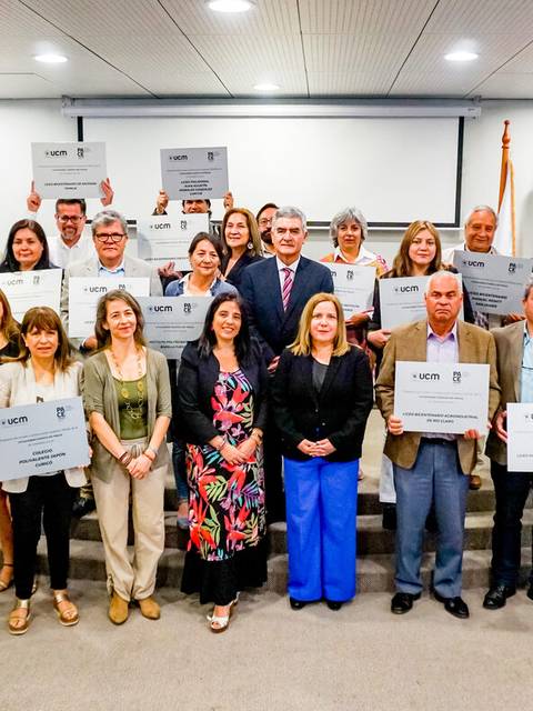 Un grupo de personas posando con certificados en un evento oficial.