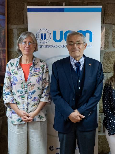 Un grupo de seis personas posando frente a un fondo de pared de piedra.