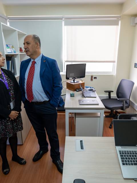 Tres personas conversan en una oficina moderna y bien iluminada.