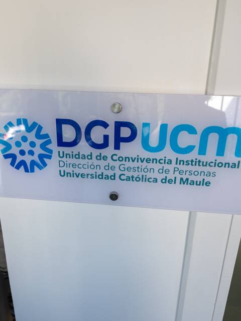 Imagen de un letrero que indica la Unidad de Convivencia Institucional de la Universidad Católica del Maule.