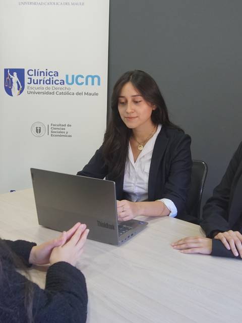 Tres mujeres conversan en una reunión profesional en una oficina.