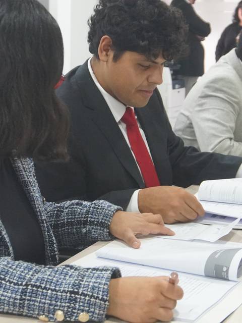Un grupo de jóvenes profesionales revisando documentos en una mesa de trabajo.