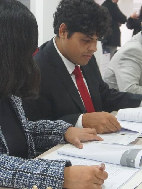 Un grupo de personas revisa documentos en una mesa de trabajo.