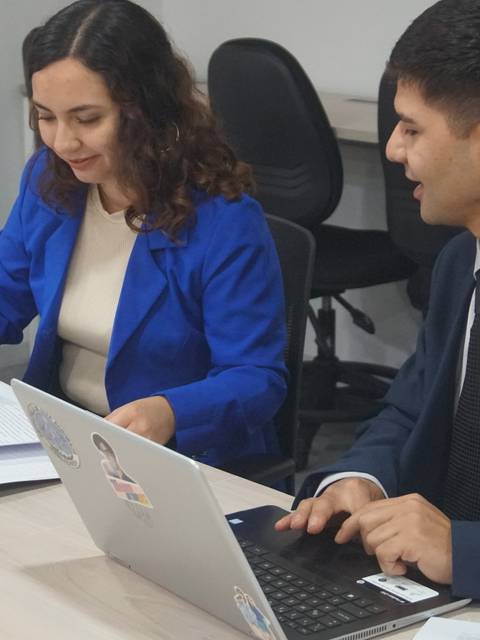 Dos personas están trabajando en una reunión en una oficina moderna.