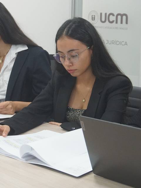 Tres mujeres revisan documentos en un entorno de oficina.