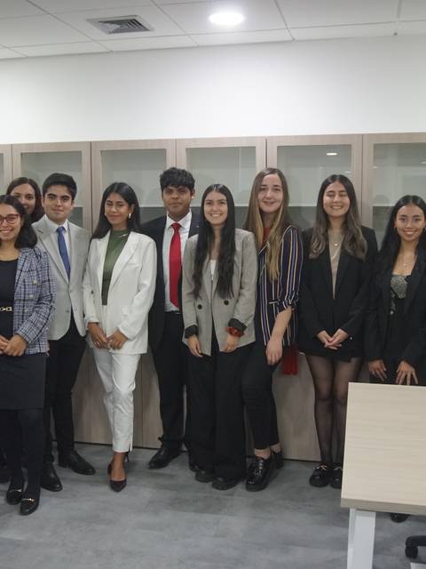 Un grupo de estudiantes en un ambiente académico, posando en un aula moderna.