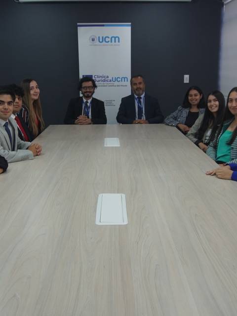 Un grupo de personas posando en una sala de reuniones moderna.