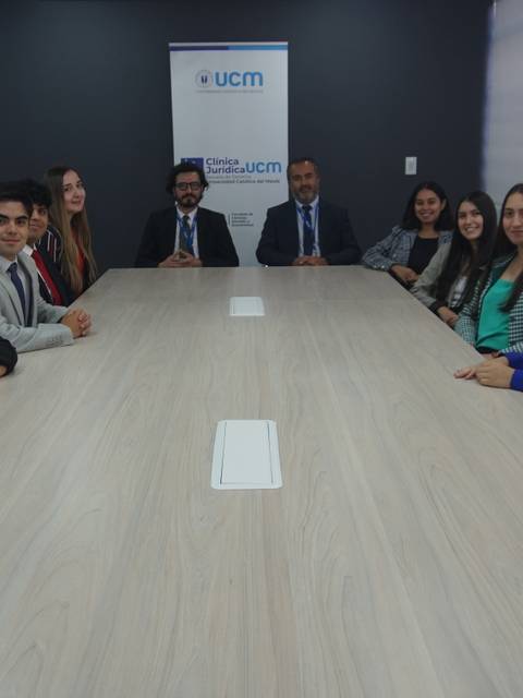 Un grupo de personas se ha sentado alrededor de una mesa en una sala de reuniones moderna.