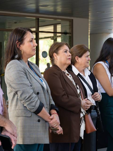 Un grupo de mujeres de pie, observando un evento al aire libre.