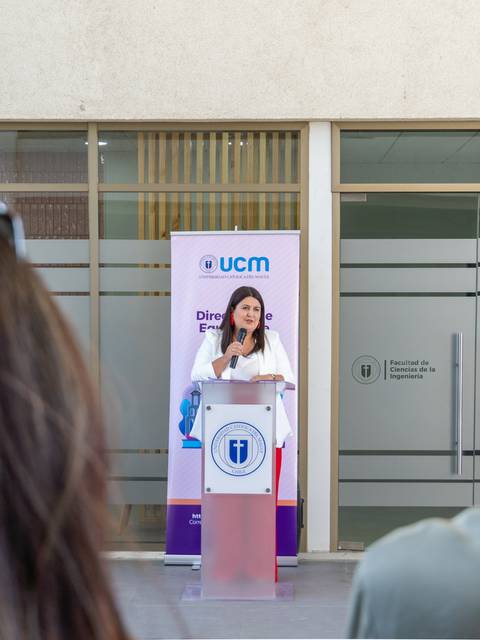 Una mujer habla en un podio durante un evento en la universidad.
