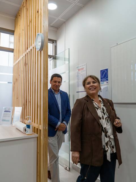 Un hombre y una mujer salen de una oficina, mostrando un ambiente profesional y moderno.