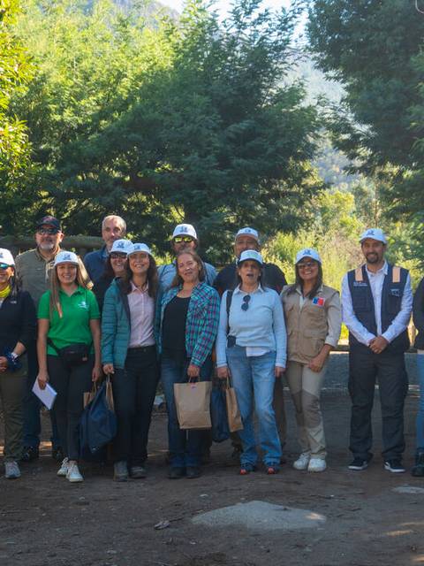 Un grupo de personas posando en un entorno natural durante un evento al aire libre.