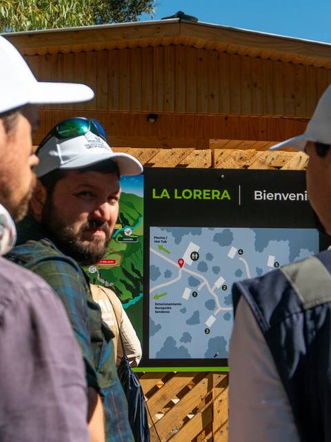 Un grupo de personas observa un mapa en un entorno natural.