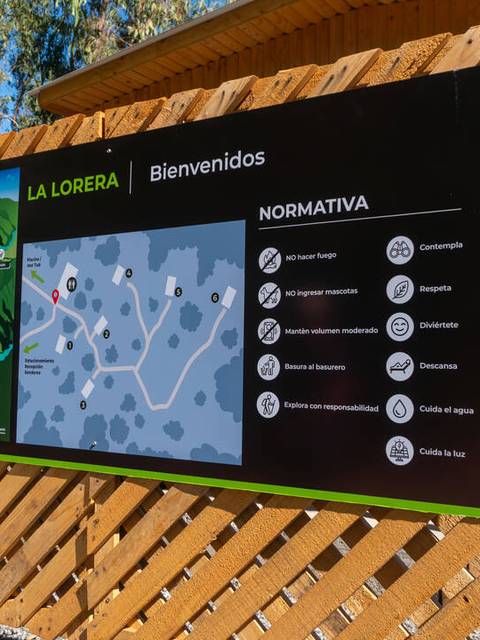 Un cartel de bienvenida que muestra un mapa de la zona de La Lorera y normas de conducta.