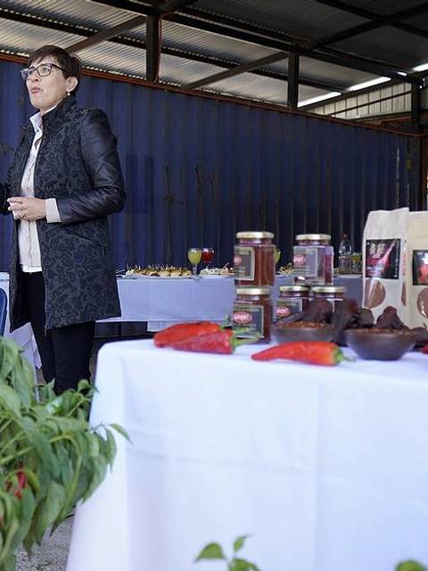 Una mujer presenta productos alimenticios en un mercado al aire libre.