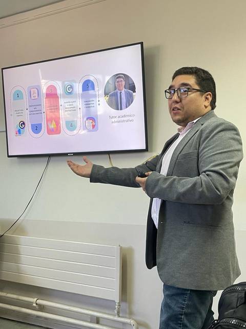 Un hombre presenta información en una pantalla durante una reunión.