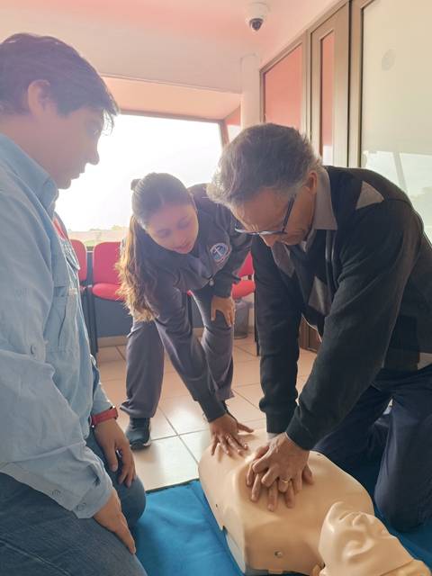 Un grupo de personas está practicando resucitación cardiopulmonar en un maniquí de entrenamiento.