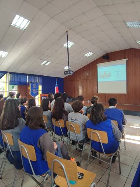 Un grupo de estudiantes asiste a una presentación en un aula.