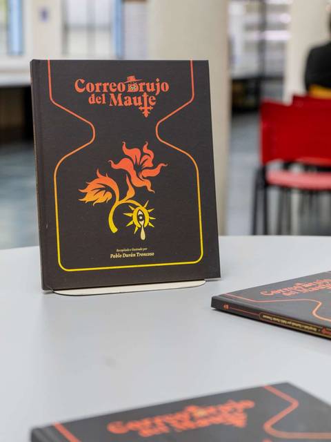Un libro titulado 'Corcostrujo del Maule' está expuesto sobre una mesa en un entorno de biblioteca.