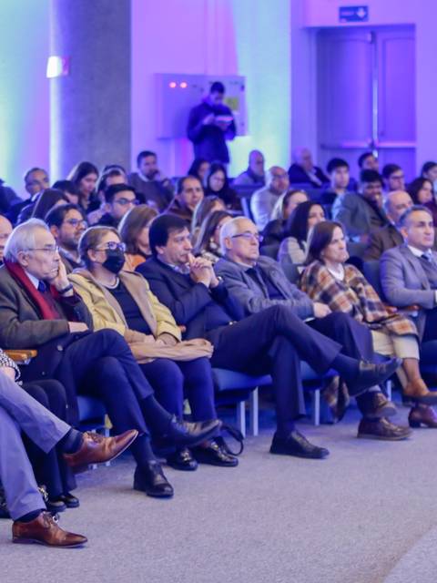 Una multitud de personas sentadas en un auditorio durante un evento.