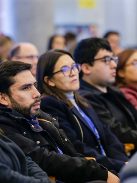 Un grupo de personas sentadas prestando atención durante un evento.
