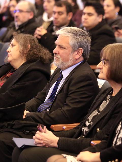 Un grupo de personas atentas y sentadas en un auditorio durante un evento.