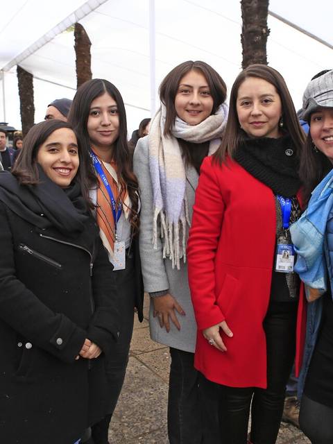 Grupo de seis mujeres posando juntas en un evento al aire libre.
