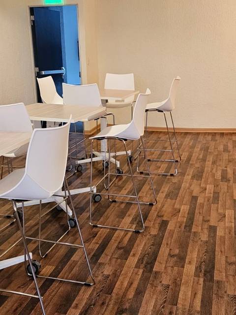 Una sala con mesas y sillas de diseño moderno, en un ambiente luminoso y acogedor.