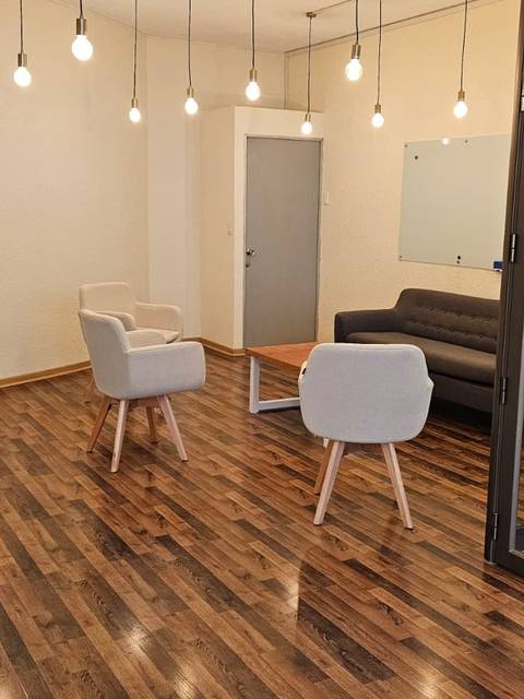 Una sala moderna con muebles sencillos y una iluminación cálida.