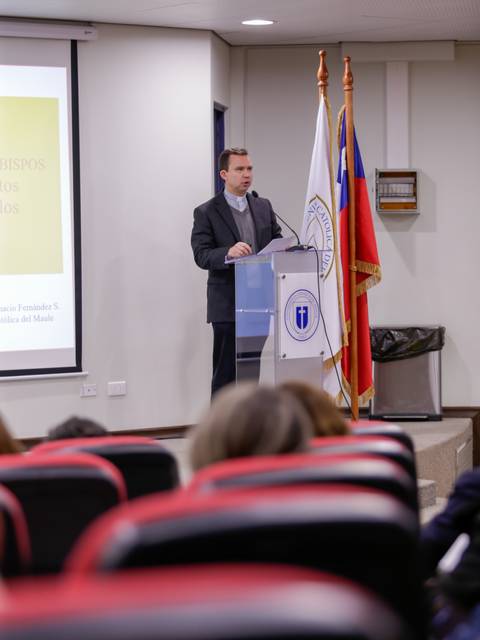 Un hombre está dando una presentación en una sala de conferencias frente a un público.
